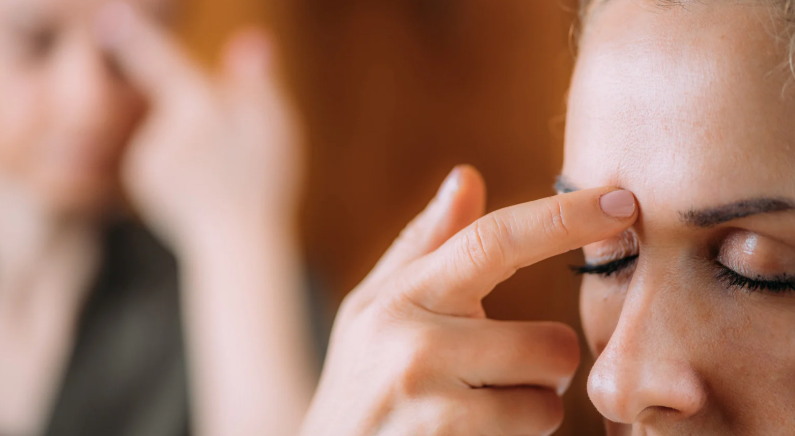 tête avec doigt sur le début de sourcil, point EFT